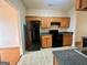 Kitchen area with oak cabinets, black appliances, and tile flooring at 6367 Ellenwood Drive, Rex, GA 30273