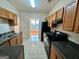 Kitchen featuring oak cabinets, dark countertops, and black appliances at 6367 Ellenwood Drive, Rex, GA 30273
