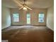 Spacious living room featuring carpet flooring and windows offering natural light at 6367 Ellenwood Drive, Rex, GA 30273