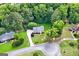Aerial view of a brick house with lush landscaping, a long driveway, and mature trees surrounding the property at 150 Tramore Trce, Tyrone, GA 30290