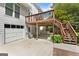 Backyard view featuring a wooden deck with stairs, a white garage door, and a well-maintained concrete patio at 150 Tramore Trce, Tyrone, GA 30290