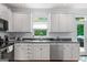 Well-lit kitchen features white cabinetry, stainless steel appliances, and view of backyard at 150 Tramore Trce, Tyrone, GA 30290