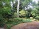 Tranquil backyard with mature trees, lush landscaping, and a brick patio at 3048 Haverford Se Ln, Marietta, GA 30067