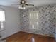 Cozy bedroom with hardwood floors, classic wallpaper, and natural light from two windows at 3048 Haverford Se Ln, Marietta, GA 30067