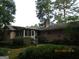 A house with a brick exterior and a screened-in porch, beautifully framed by lush greenery and mature trees in a serene setting at 3048 Haverford Se Ln, Marietta, GA 30067
