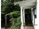 Exterior side view of the home featuring a covered entryway and lush landscaping at 3048 Haverford Se Ln, Marietta, GA 30067