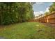 Large, well-maintained backyard with a wooden fence and green lawn at 65 Cold Harbor Ct, Sharpsburg, GA 30277