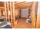 Unfinished basement with exposed framing, a concrete floor, a double-door access to the exterior, and storage items at 65 Cold Harbor Ct, Sharpsburg, GA 30277