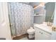 Cozy bathroom featuring white cabinets, white countertops, a decorative shower curtain, and built-in shelving at 65 Cold Harbor Ct, Sharpsburg, GA 30277