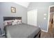 Bedroom featuring gray walls, wood-look floors, a double-door closet, and a large bed with decorative pillows at 65 Cold Harbor Ct, Sharpsburg, GA 30277