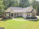 Charming single-story home featuring a well-manicured lawn, brick accents, and a welcoming front porch at 65 Cold Harbor Ct, Sharpsburg, GA 30277