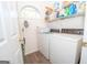 Bright laundry room features a washer, dryer, shelving, and gray vinyl flooring at 65 Cold Harbor Ct, Sharpsburg, GA 30277