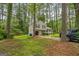 Charming two-story home with neutral siding, black shutters, an attached garage and a lawn with mature trees at 447 Sherwood Cir, Stone Mountain, GA 30087