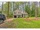 Charming two-story home with neutral siding, black shutters, an attached garage and a lawn with mature trees at 447 Sherwood Cir, Stone Mountain, GA 30087