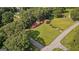 Aerial view of a well-maintained home with a red roof, nestled on a spacious green lot with mature trees at 6674 Cowan Mill Rd, Winston, GA 30187