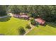 Aerial view of a well-maintained home with a red roof, nestled on a spacious green lot with mature trees at 6674 Cowan Mill Rd, Winston, GA 30187