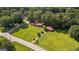 Aerial view of a well-maintained home with a red roof, nestled on a spacious green lot with mature trees at 6674 Cowan Mill Rd, Winston, GA 30187