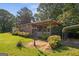Outdoor oasis, including lush greenery, patio, covered deck, and convenient covered parking area at 6674 Cowan Mill Rd, Winston, GA 30187