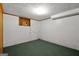 Finished basement space with green carpet, white walls, and an air conditioning unit, offering potential for various uses at 6674 Cowan Mill Rd, Winston, GA 30187