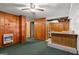 Basement featuring wood paneled walls, retro bar with sink, and a doorway leading to a kitchenette with vintage appliances at 6674 Cowan Mill Rd, Winston, GA 30187