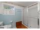 This full bathroom offers a shower, tub, and bright blue tiled walls with a large window at 6674 Cowan Mill Rd, Winston, GA 30187
