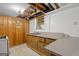 Basement kitchenette area with a vintage stove, sink, wood paneled walls, and overhead lighting adding character at 6674 Cowan Mill Rd, Winston, GA 30187