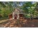 Outdoor shed featuring wood construction, storage, and a covered area, nestled in the woods at 6674 Cowan Mill Rd, Winston, GA 30187