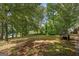 A tranquil backyard setting with lush greenery, mature trees, and a set of stairs at 6674 Cowan Mill Rd, Winston, GA 30187