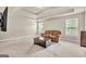 Spacious carpeted living room with tray ceiling, a comfortable recliner, and two large windows at 2619 Dayview, Atlanta, GA 30331