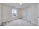Clean, empty bedroom with neutral carpet, a window, and a door at 366 Whitney Ln, Mcdonough, GA 30253