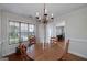 Dining room featuring a wooden table, chairs, and chandelier beneath a large window at 366 Whitney Ln, Mcdonough, GA 30253