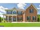 Charming two-story home with brick and vinyl siding, green shutters, landscaped yard and covered porch at 366 Whitney Ln, Mcdonough, GA 30253