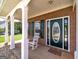 Charming front porch featuring brick accents, white rocking chair, and a decorative front door with sidelights at 366 Whitney Ln, Mcdonough, GA 30253