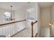 Bright hallway with white railings, a chandelier, and a view into a bedroom at 366 Whitney Ln, Mcdonough, GA 30253