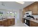 Well-lit kitchen featuring wooden cabinets, tile flooring, and access to the dining area at 366 Whitney Ln, Mcdonough, GA 30253
