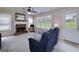 Cozy living room featuring a brick fireplace, large windows, and a comfortable blue sofa at 366 Whitney Ln, Mcdonough, GA 30253