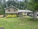 Charming two-story home with a metal roof, landscaped yard, and a covered carport for convenient parking at 1791 Little Fawn Nw Trl, Conyers, GA 30012