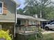 A view of the home's entrance with a cozy porch, plants, and ample covered parking at 1791 Little Fawn Nw Trl, Conyers, GA 30012