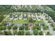 Wide aerial shot showcasing a residential neighborhood, featuring manicured lawns and mature trees on a sunny day at 308 Sarasota Ln, Locust Grove, GA 30248