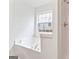 Bathroom features a white tub, a window, and a shower at 308 Sarasota Ln, Locust Grove, GA 30248