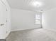 Bright bedroom with neutral carpet, complemented by a textured ceiling and natural light at 308 Sarasota Ln, Locust Grove, GA 30248