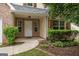 Inviting front entrance with a white door, sidelight windows, and well-manicured landscaping with established bushes at 308 Sarasota Ln, Locust Grove, GA 30248
