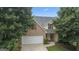 Charming two-story brick home featuring an attached two-car garage and a well-maintained front lawn and manicured landscaping at 308 Sarasota Ln, Locust Grove, GA 30248