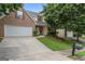 Charming two-story brick home featuring an attached two-car garage and a well-maintained front lawn and manicured landscaping at 308 Sarasota Ln, Locust Grove, GA 30248