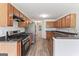 Well-lit kitchen features stainless steel appliances, wood cabinets, and dark countertops at 308 Sarasota Ln, Locust Grove, GA 30248