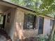 Side view of brick exterior with weathered wooden shutters and a doorway at 6337 Wellington Way, Austell, GA 30106