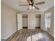 This bedroom features wood-look floors, ceiling fan, and two closets, all illuminated with an abundance of natural light at 11 Grove Ln, Hampton, GA 30228