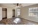 This bedroom features wood-look floors, ceiling fan, closet, and an abundance of natural light from the window at 11 Grove Ln, Hampton, GA 30228