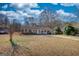 Classic brick home with large front yard, white picket fence, and mature trees enhancing curb appeal at 11 Grove Ln, Hampton, GA 30228