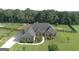 Beautifully landscaped home with lush green lawn, mature trees, and a long driveway at 116 Standford Dr, Mcdonough, GA 30252